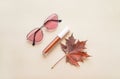 Autumn beauty or fashion composition ÃÂ¢Ã¢âÂ¬Ã¢â¬Å bronze lip gloss  and pink sunglasses. Fall makeup concept Royalty Free Stock Photo